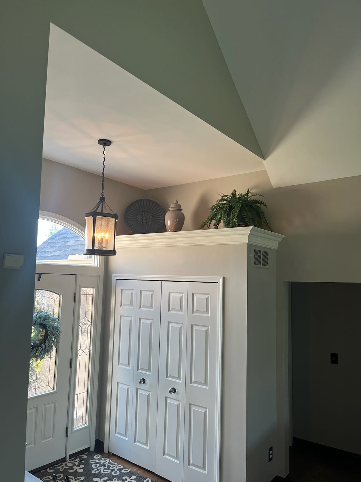 Foyer with sage green vaulted ceiling and white trim